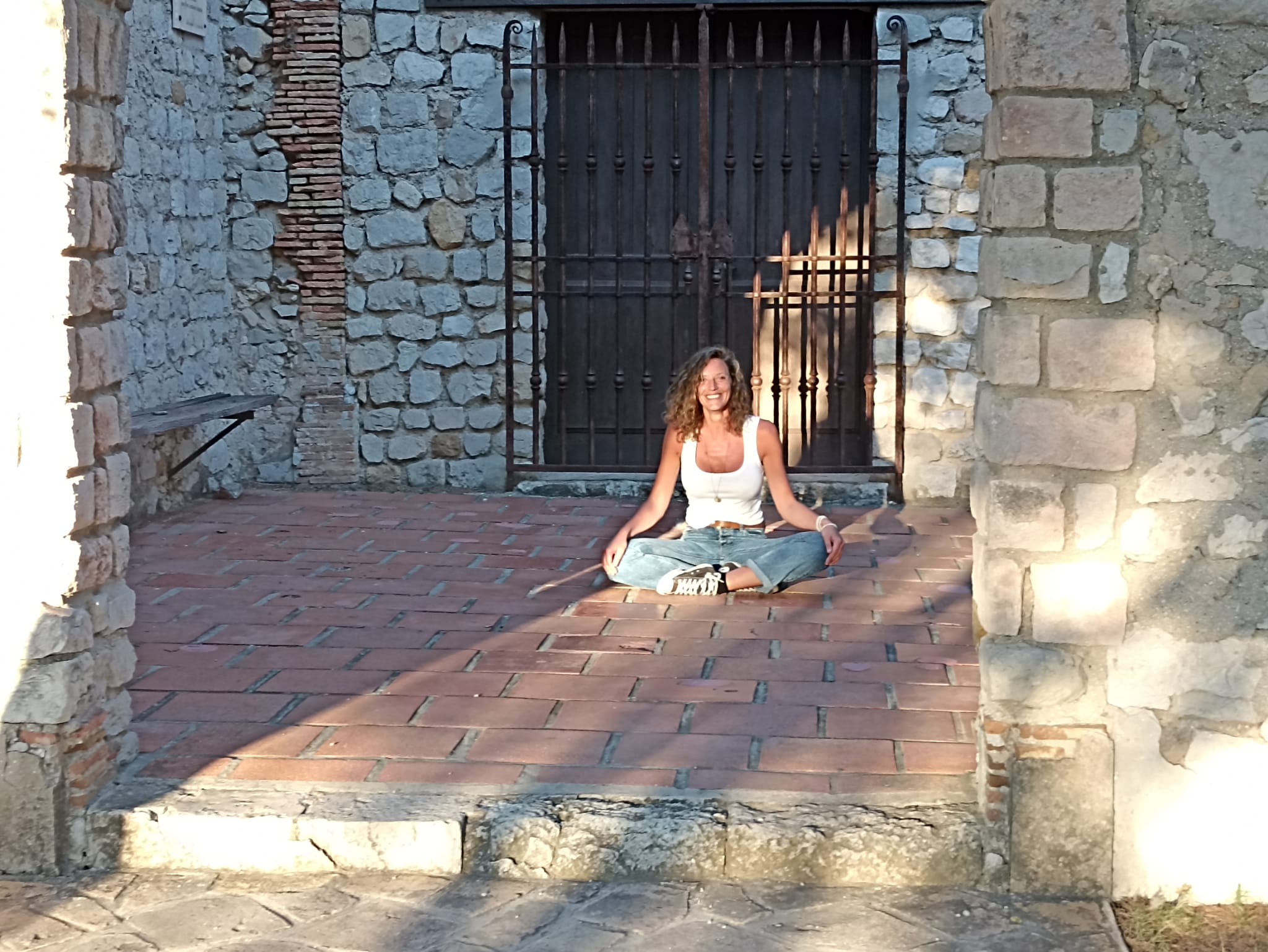 Céline pratiquant le yoga Nidra en position de lotus à la chapelle de Carry Le Rouet, un moment de détente et de connexion. Céline, fondatrice d’Immersive Expérience , Massage à Domicile Côte Bleue.