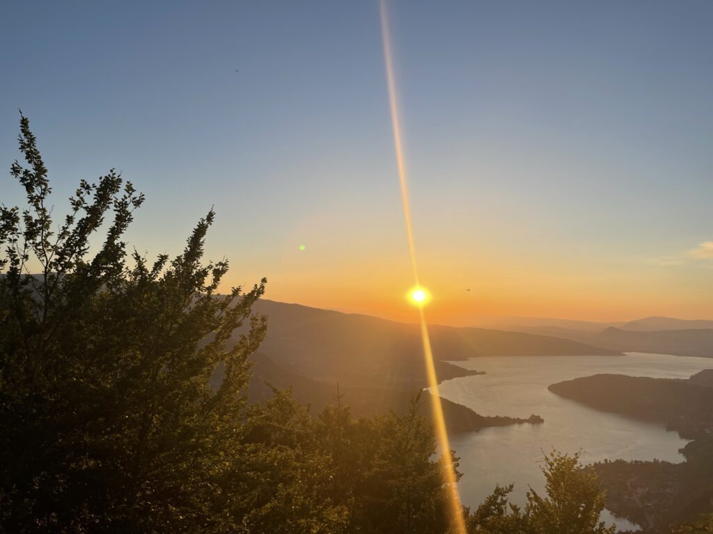 Coucher de soleil sur les hauteurs du lac d’Annecy, illustrant la beauté de la nature et l’importance du ressourcement.