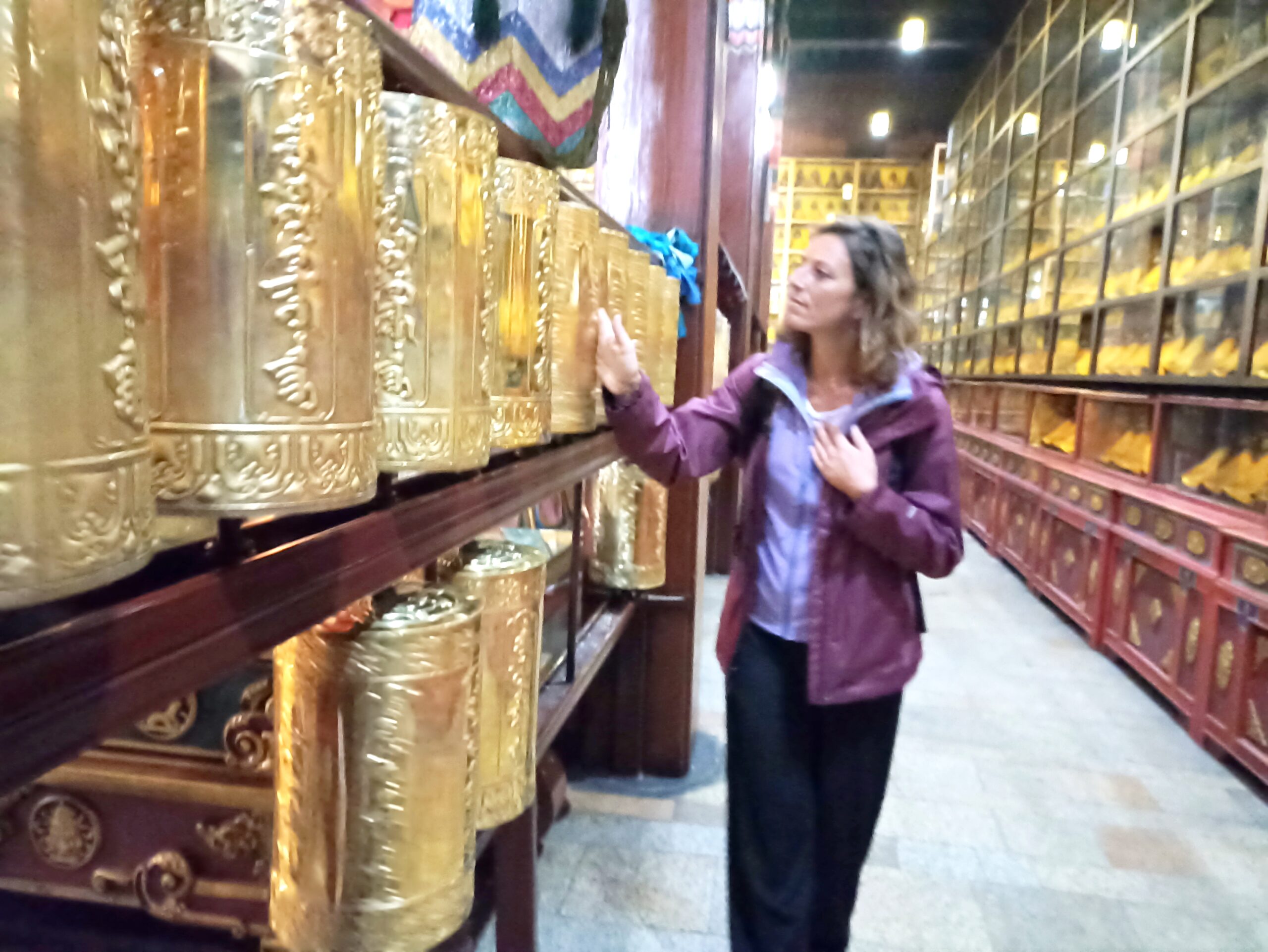 Céline en voyage en Mongolie découvrant le Bouddha géant au Monastère de Gandantegchinlin, un lieu sacré pour la spiritualité et la méditation.